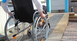 Frau im Rollstuhl auf Rollstuhlrampe